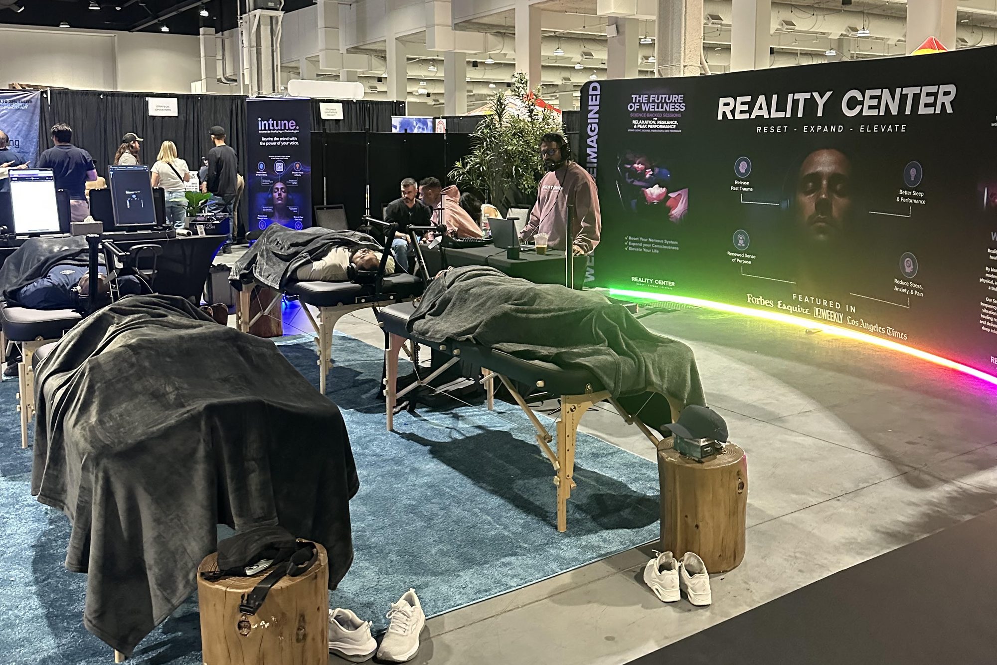 Reality Center’s wellness activation on the MCON expo floor: attendees on every session table, staff at the check-in desk and the lit Reality Center backdrop