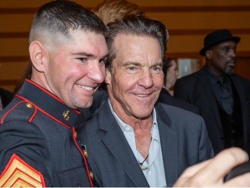 A Marine in dress blues meeting a guest at an MV Awards event.
