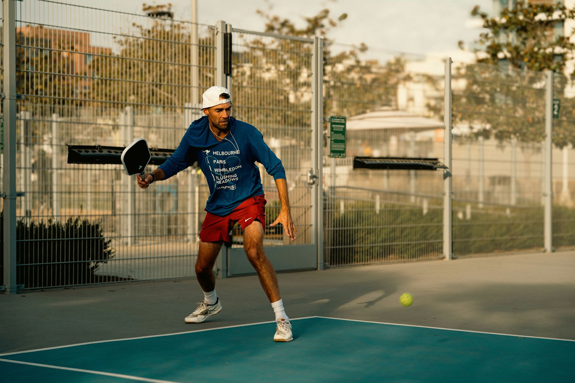 A player stretching for a forehand at golden hour