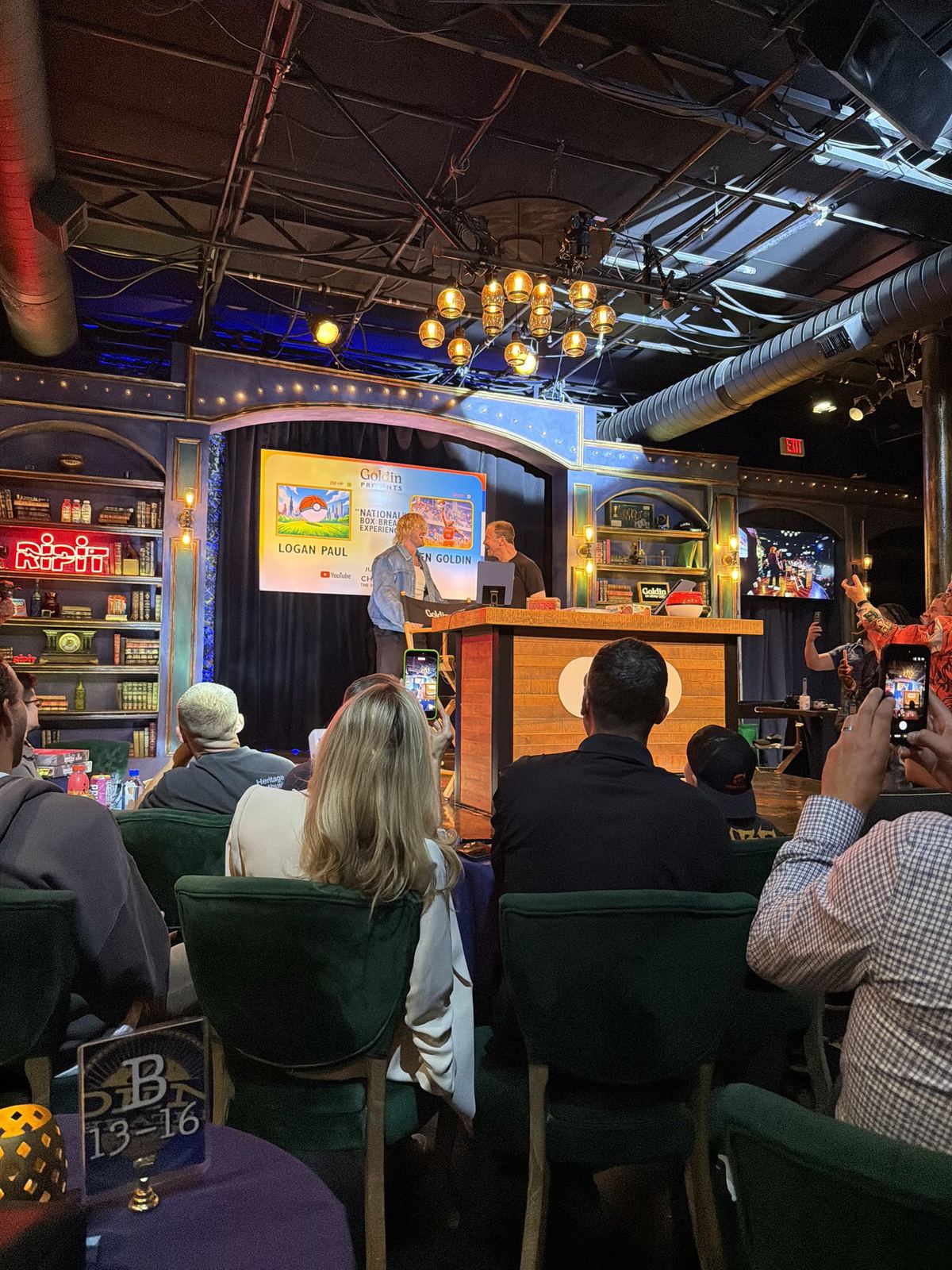 A packed room watching a live box break on stage at Goldin's National Box Break Experience.