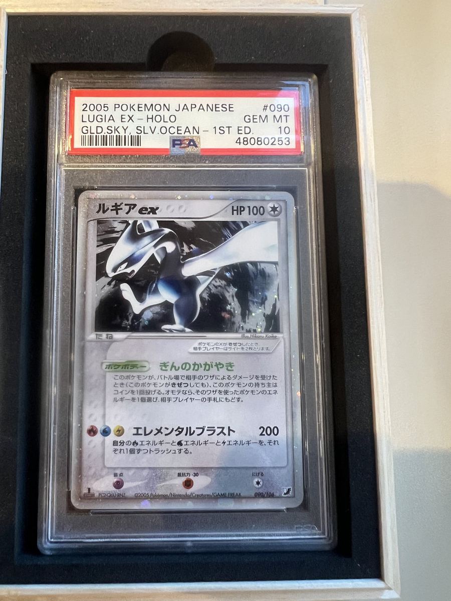 A 2005 Japanese Lugia ex, graded PSA 10 Gem Mint, seated in a display case.